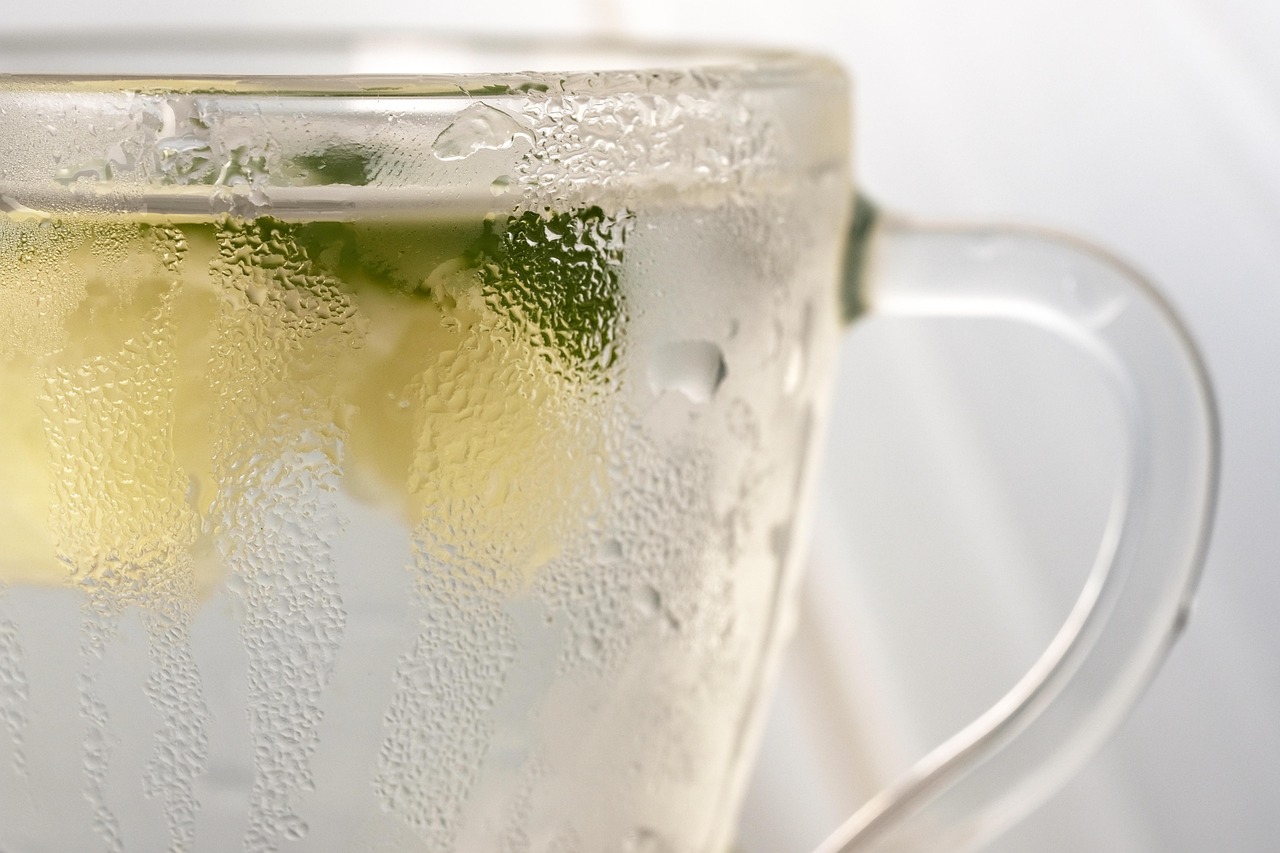 Tazza di acqua calda con limone su un tavolo, simbolo di salute e benessere.